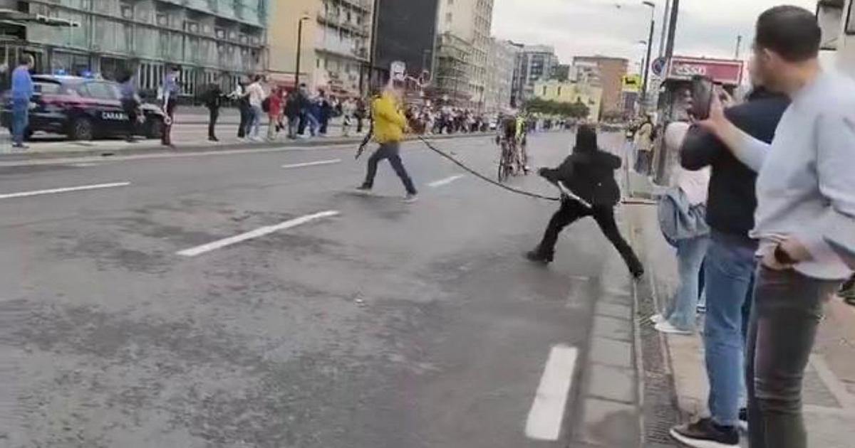 Джиро д'Италия, 67-летний мужчина стоит перед группой с трубкой, серьезный риск для велосипедистов